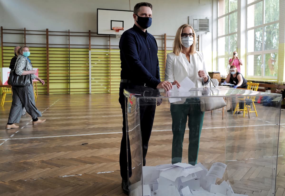 Rafal Trzaskowski äänestää vaimo vierellään.