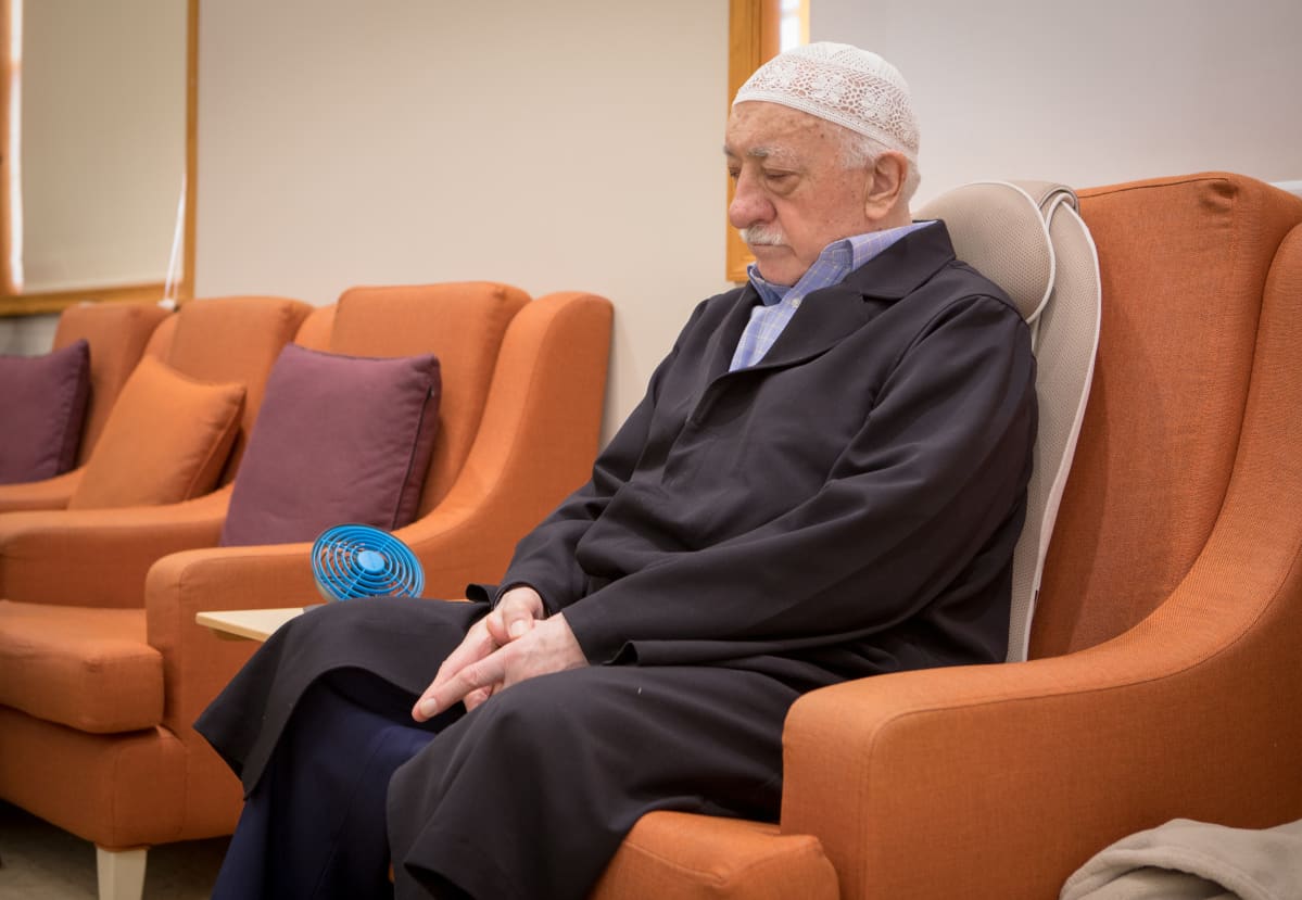 Mies istuu tuolissa. Fethullah Gülen