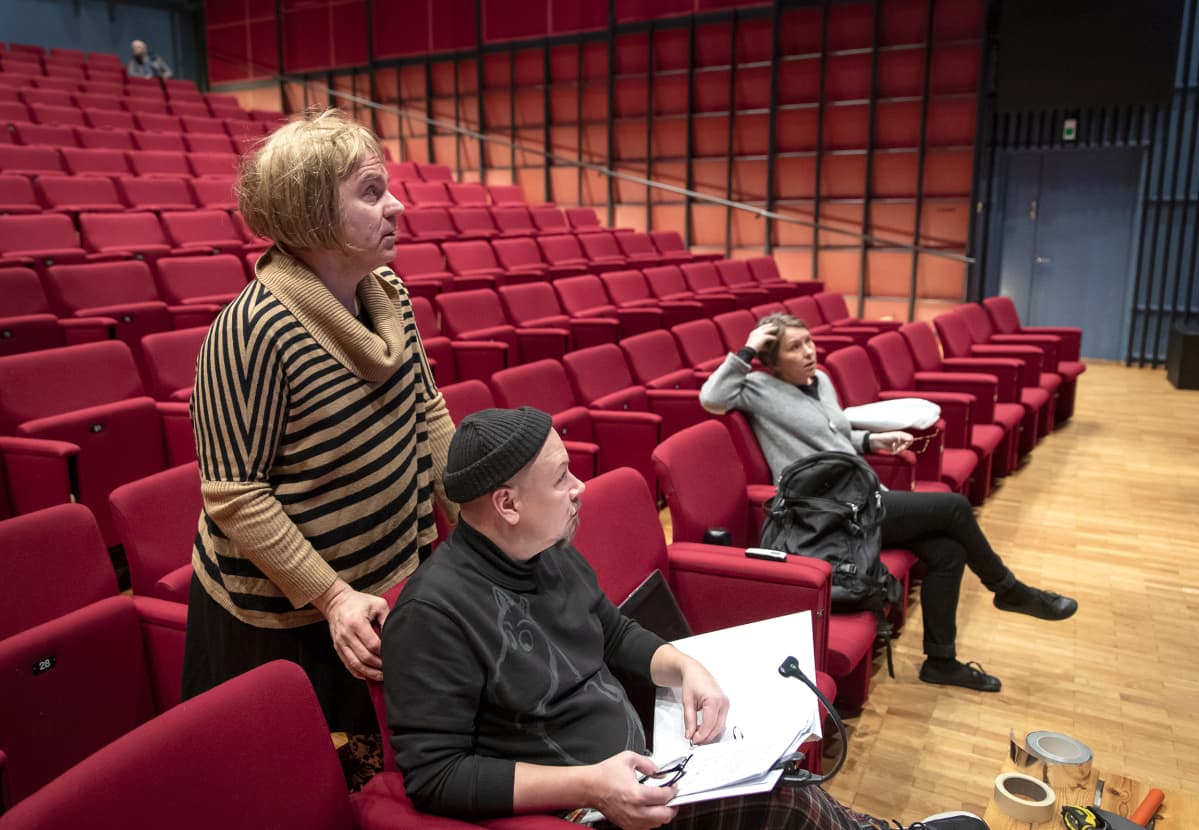 Ohjaaja Antti Lattu, puvustaja Tommi Haapaniemi ja vastaava ohjaaja Hannele Martikainen seuraavat näytelmäharjoituksia.