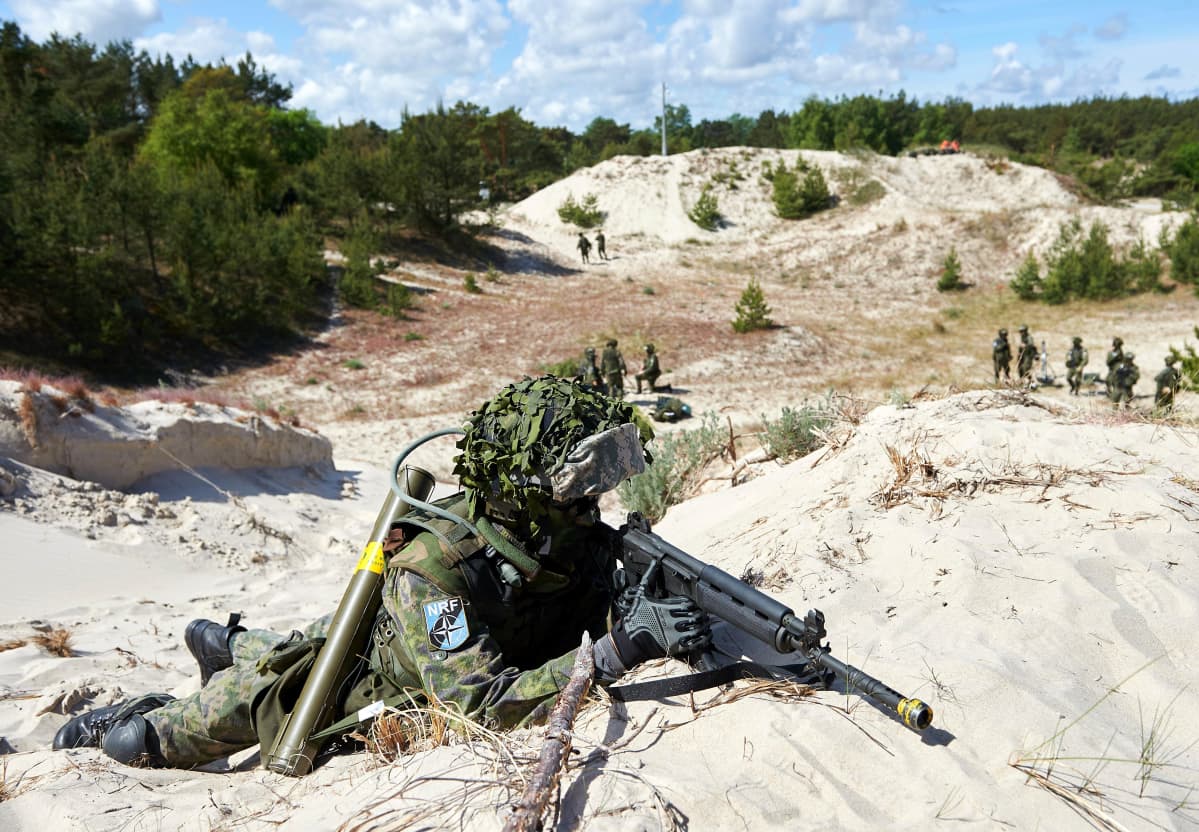 sotilas rynnäkkökivääreineen hiekkadyynillä
