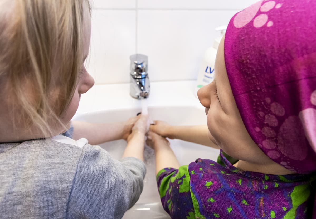 Tytöt pesevät käsiään.