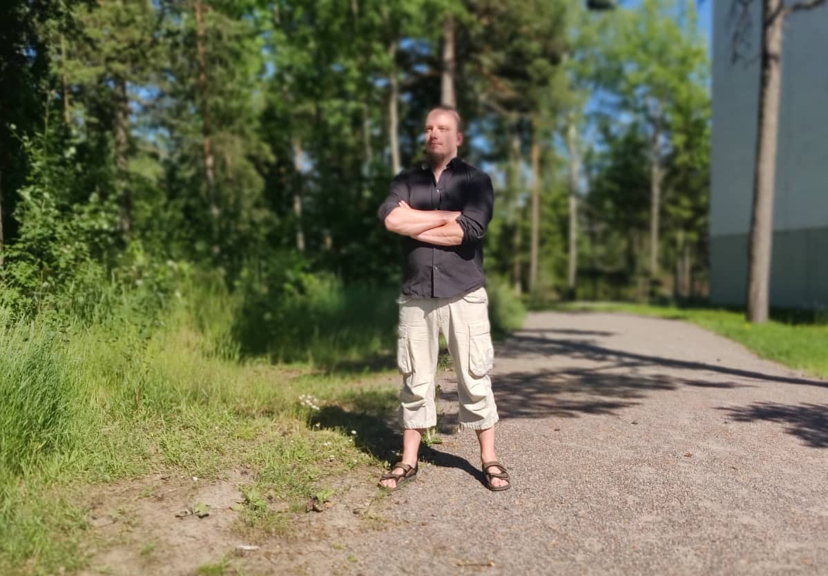 Tony Rintala seisoo kotitalonsa pihalla Helsingissä.