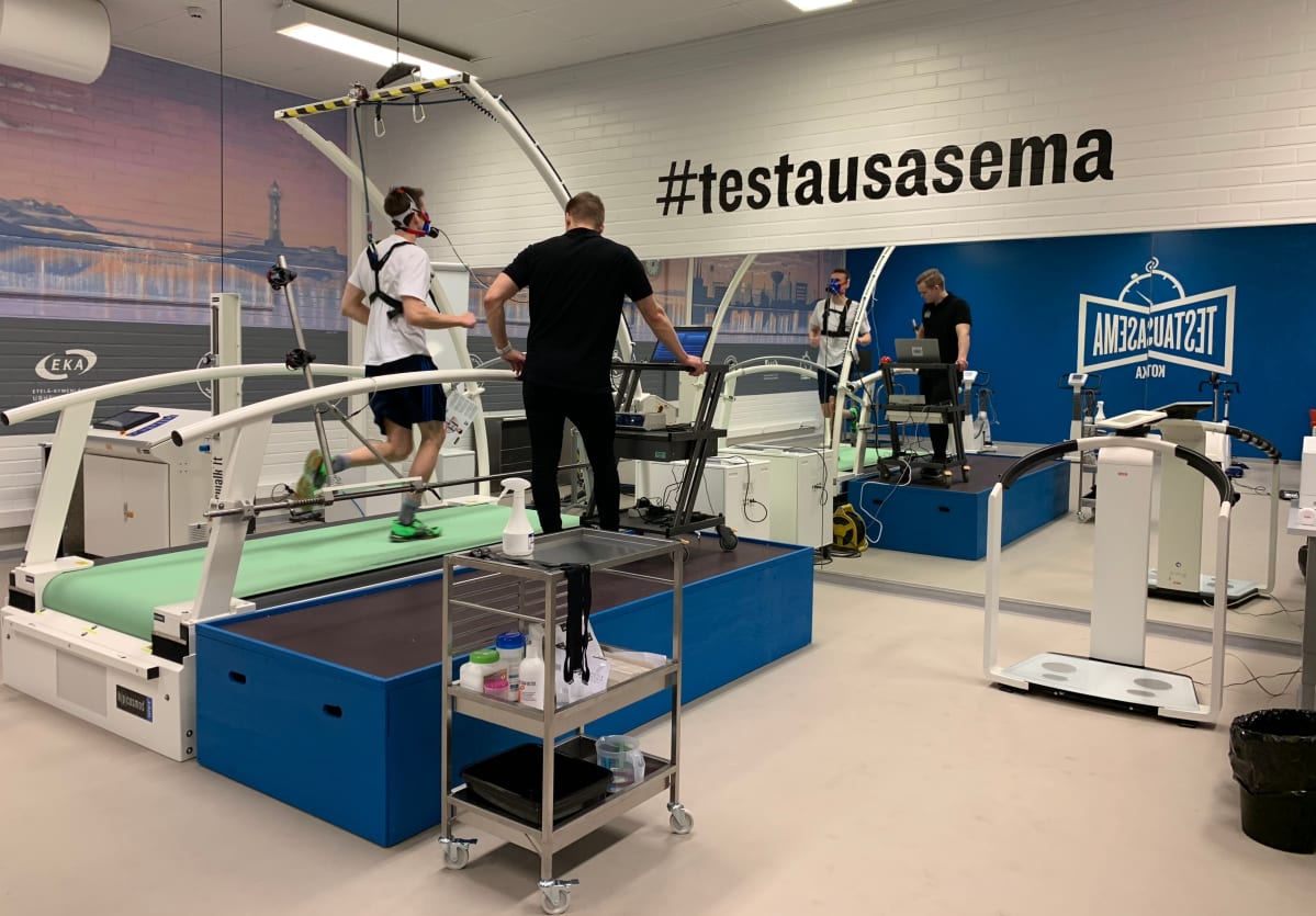 Tapani Laakso juoksee juoksumatolla hengityskaasuanalysaattori kasvoillaan Kotkan uudella testausasemalla.