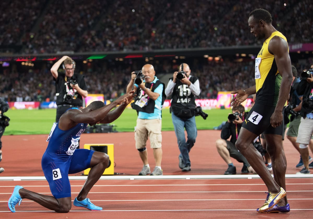 Tuore maailmanmestari Justin Gatlin polvistuu Usain Boltin edessä.