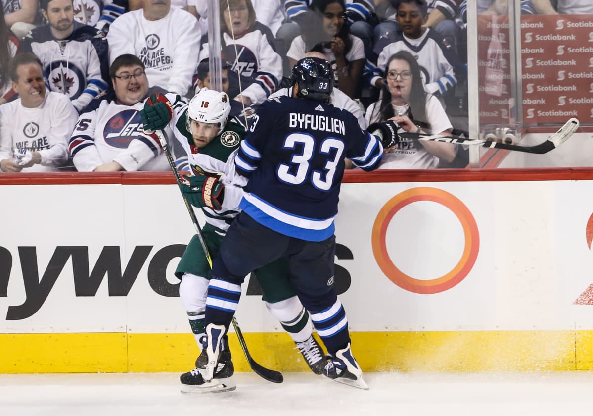 Winnipegin Dustin Byfuglien taklaa Minnesotan Jason Zuckeria.