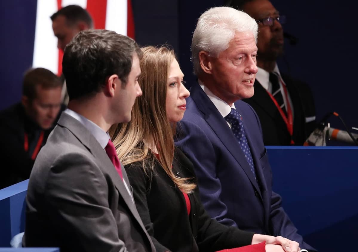 Marc Mezvinsky, Chelsea Clinton ja Bill Clinton istumassa vierekkäin,