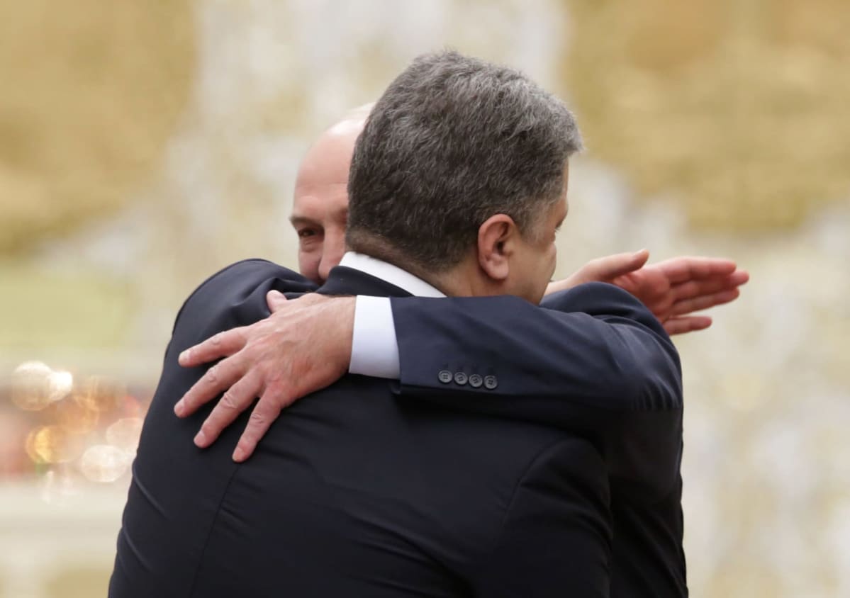 Valko-Venäjän presidentti Aljaksandr Lukašenka halaa Ukrainan presidenttiä Petro Porošenkoa.