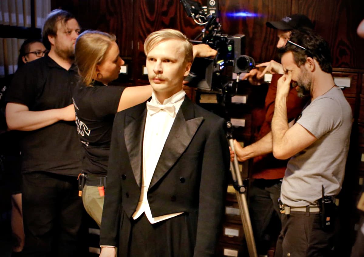 Oskar Pöysti, joka esittää Eugen Schaumannia, valmistautuu ottoon. Ohjaaja Lauri Maijala takana toinen vasemmalta.