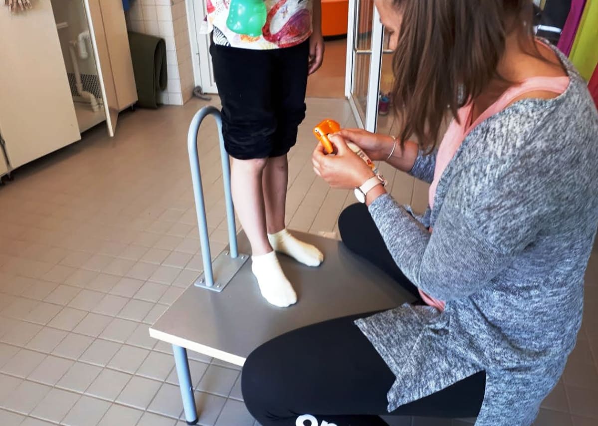 Isokylän monitoimitalon lastenhoitaja Laura Niemi levittää lapsille soveltuvaa aurinkorasvaa, ergonomisella lastenhoitotasolla.