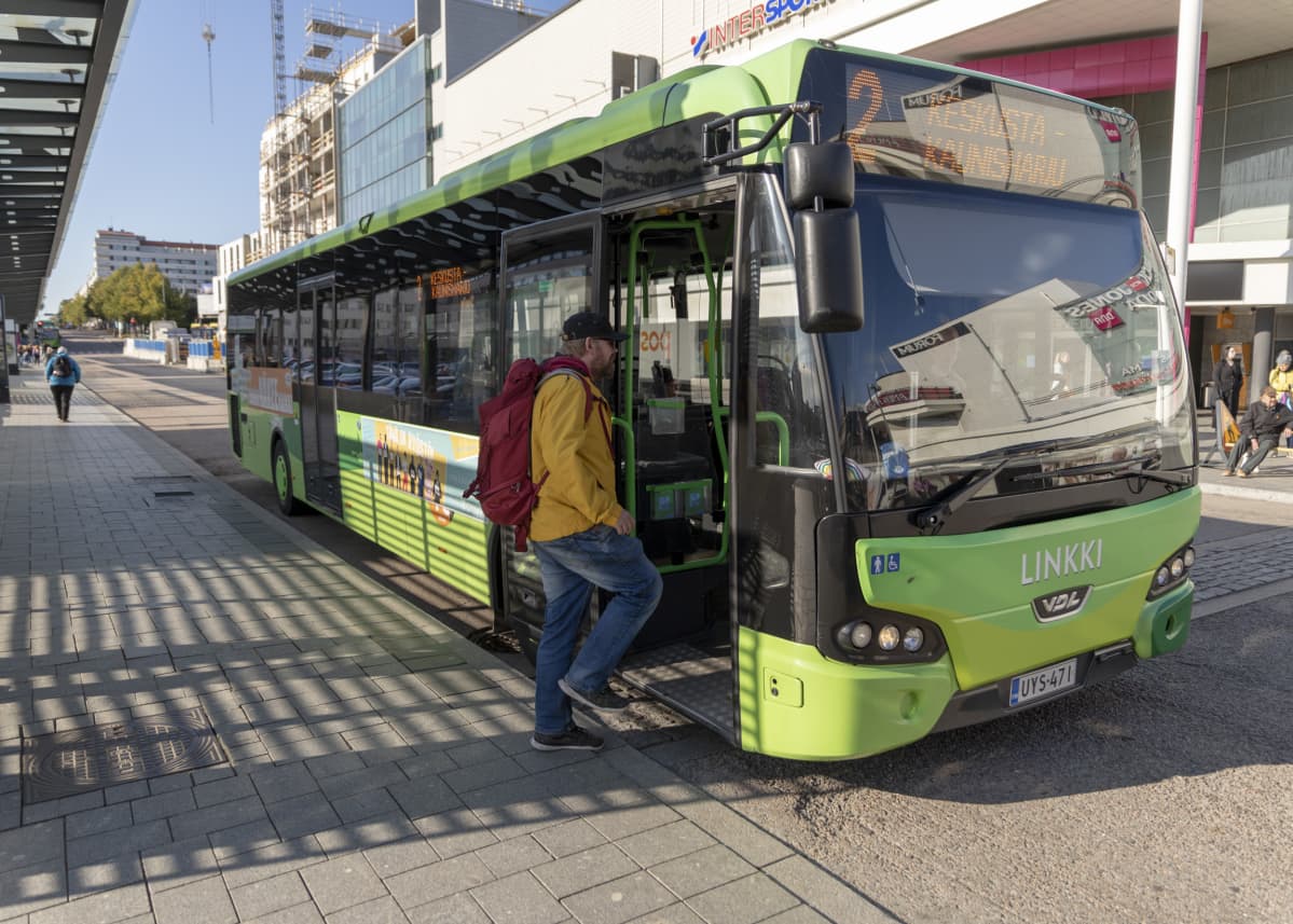 Mies nousee bussiin Jyväskylän paikallisliikenneterminaalissa.