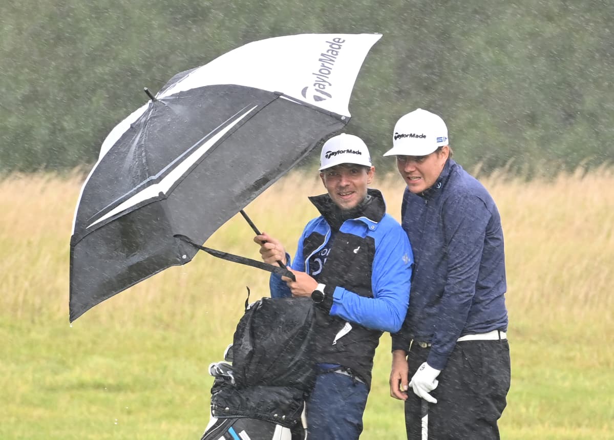 Sami Välimäki (oik.) ja caddie Väinö Viitaharju sateen suojassa Walesissa Euroopan kiertueella.