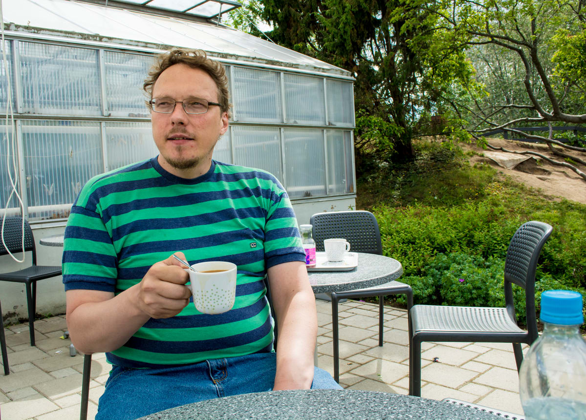 Osmo Hyövälti istuu kahvilassa