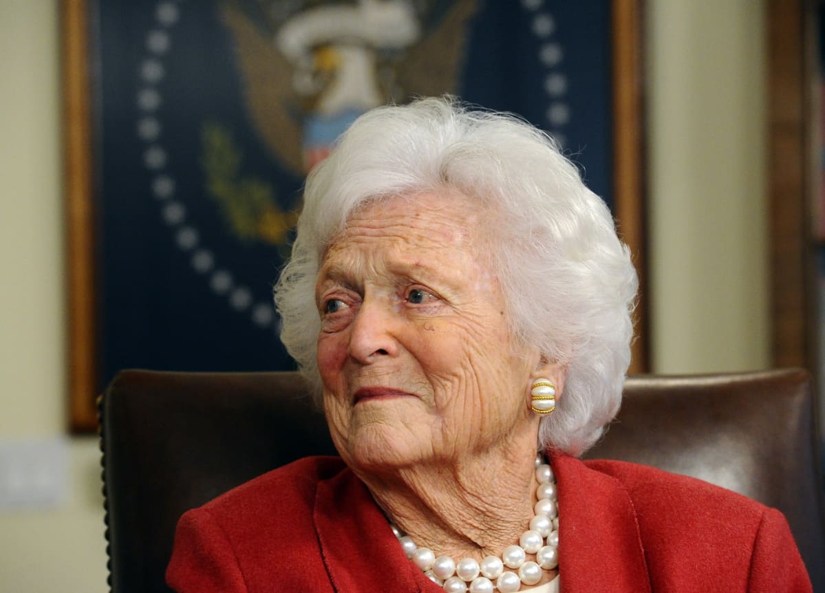 Barbara Bush kasvokuva. Pukeutunut punaiseen jakkuun ja helmikaulakoruun.