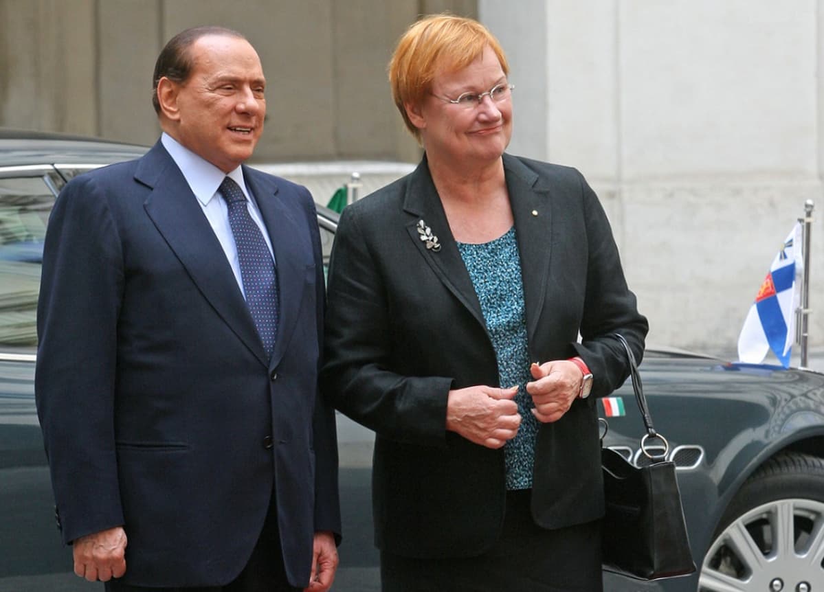 Berlusconi ja Halonen, taustalla auto, jonka nokassa Suomen valtiolippu leijonavaakunoineen.