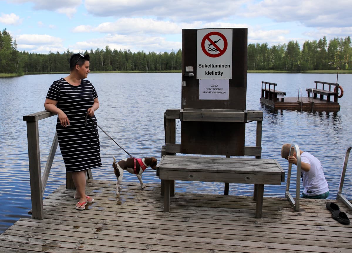 Susanna Lahtinen koiransa Elsan ja poikansa Alexin kanssa Valkiajärven rannalla Purhon leirintäalueella.
