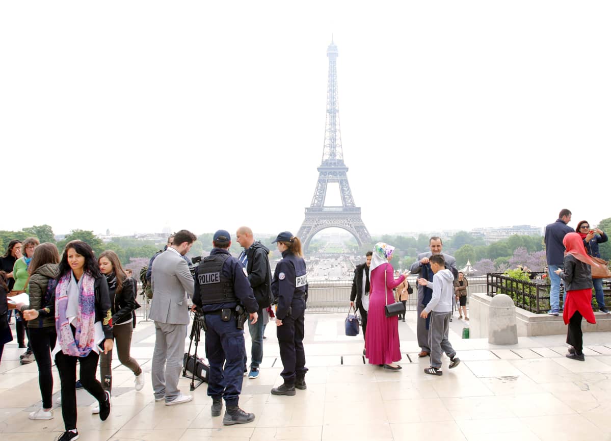 Poliisit tarkistavat henkilötodistuksia Eiffel-tornin läheisyydessä Pariisissa.
