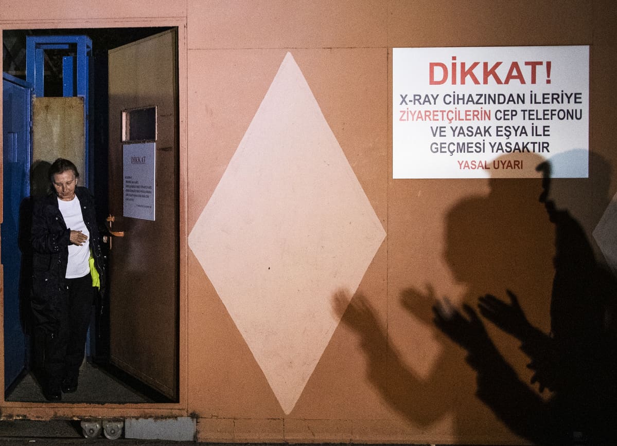 Nainen kävelee ulos vankilasta.