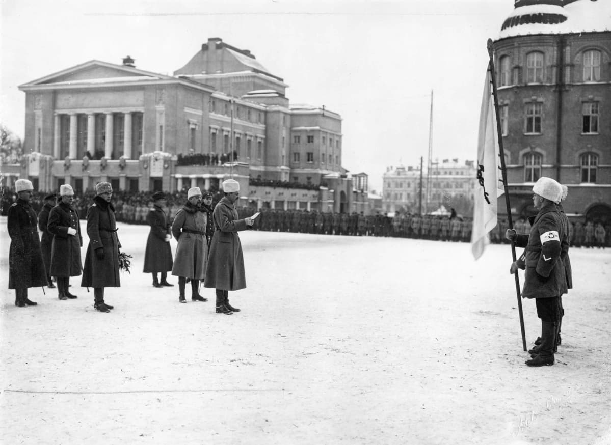 Miehet seisovat torilla sodan alkamisen muistokatselmuksessa.
