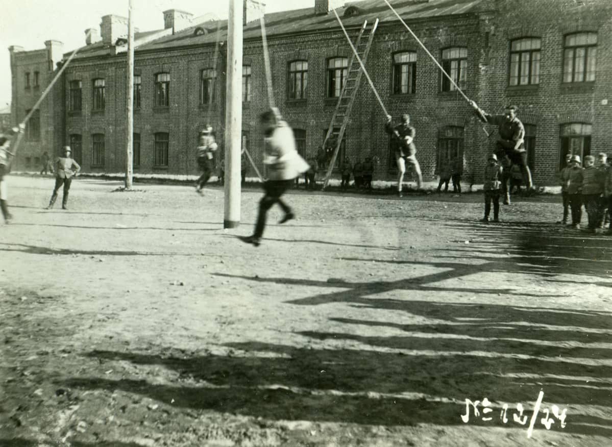 Lappeenrannan varuskunta. Harjoitus ns. köysikarusellissa päävartion kentällä, miehet roikkuvat köyden varassa pyörityksessä vuonna 1924.