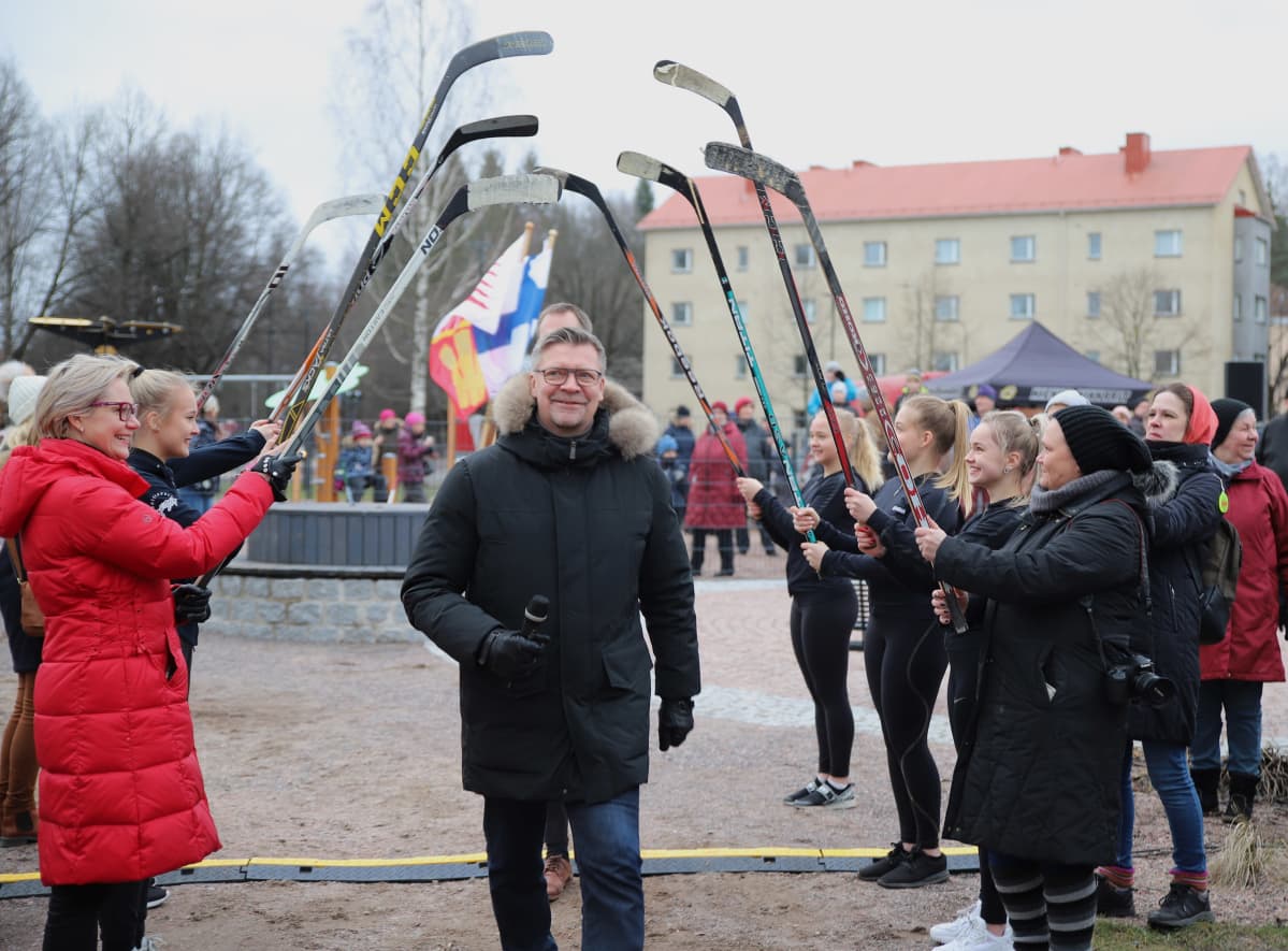 Jukka Jalonen kulkee jääkiekkomailojen ali Jukka Jalosen puiston nimiäisissä.