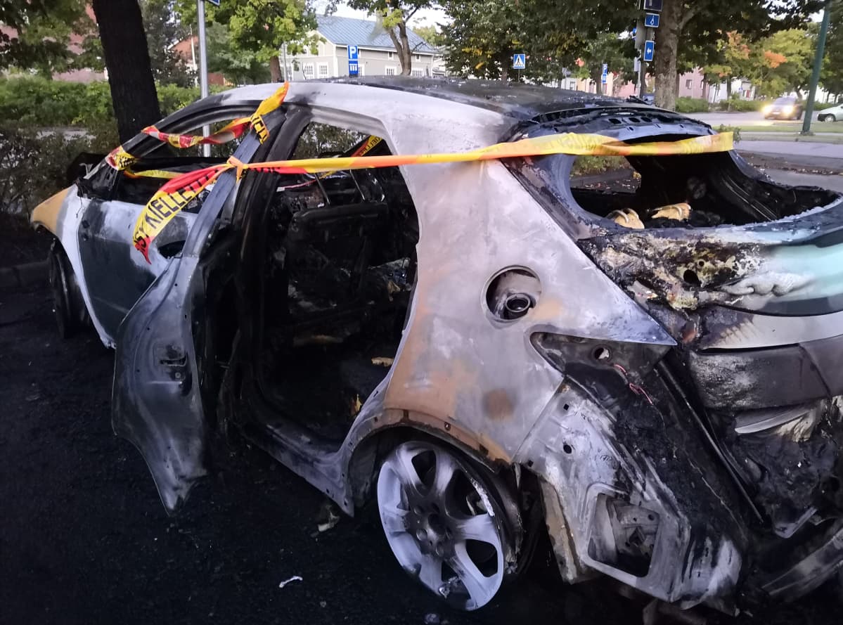 Pahasti palanut auto, jonka ympärillä punakeltainen nauha.