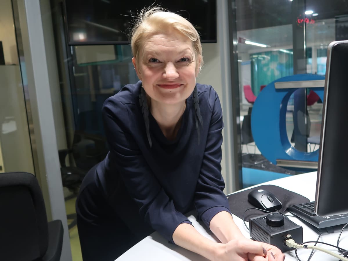 Maarit Kalmakurki nojaa radiostudion pöytään
