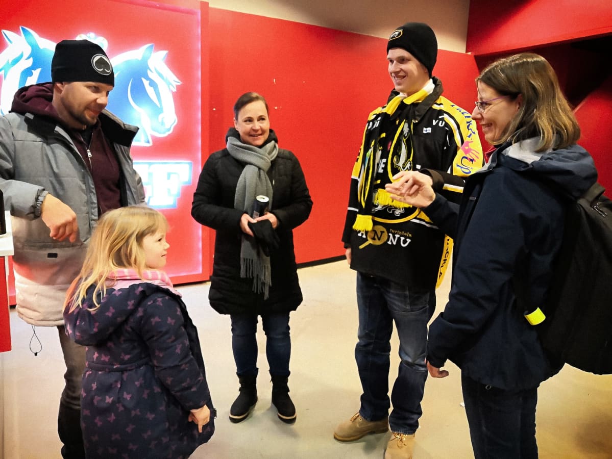 Aarne keskustelee jääkiekkopelin erätauolla tapaamansa perheen kanssa.