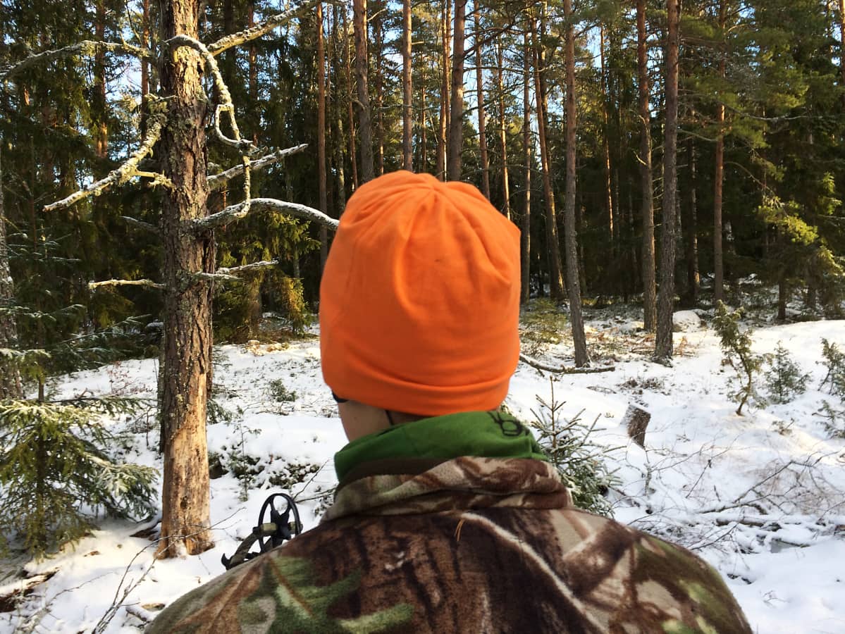 Metsästäjä seisoo metsässä.