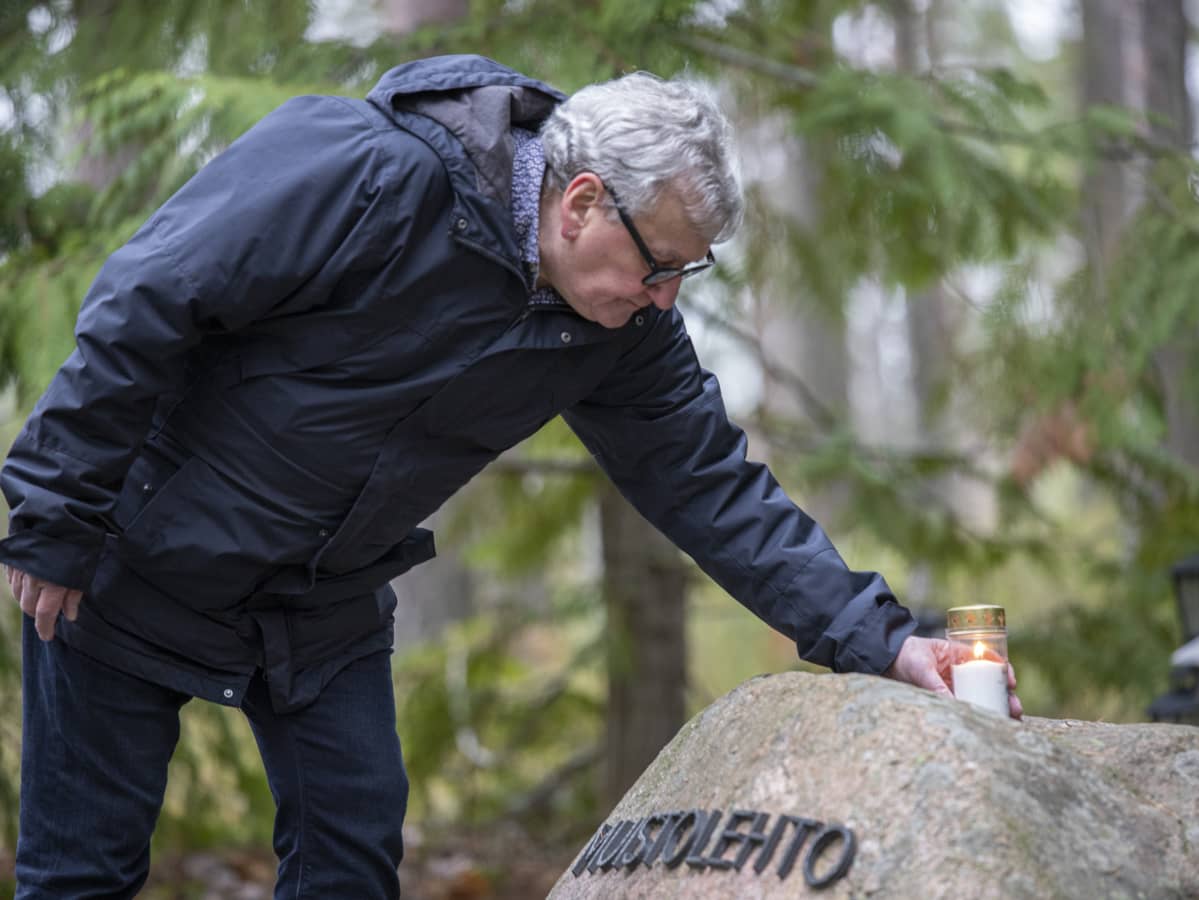 Jukka Leminen tuomassa kynttilää Tainionkosken hautausmaan muistolehtoon.