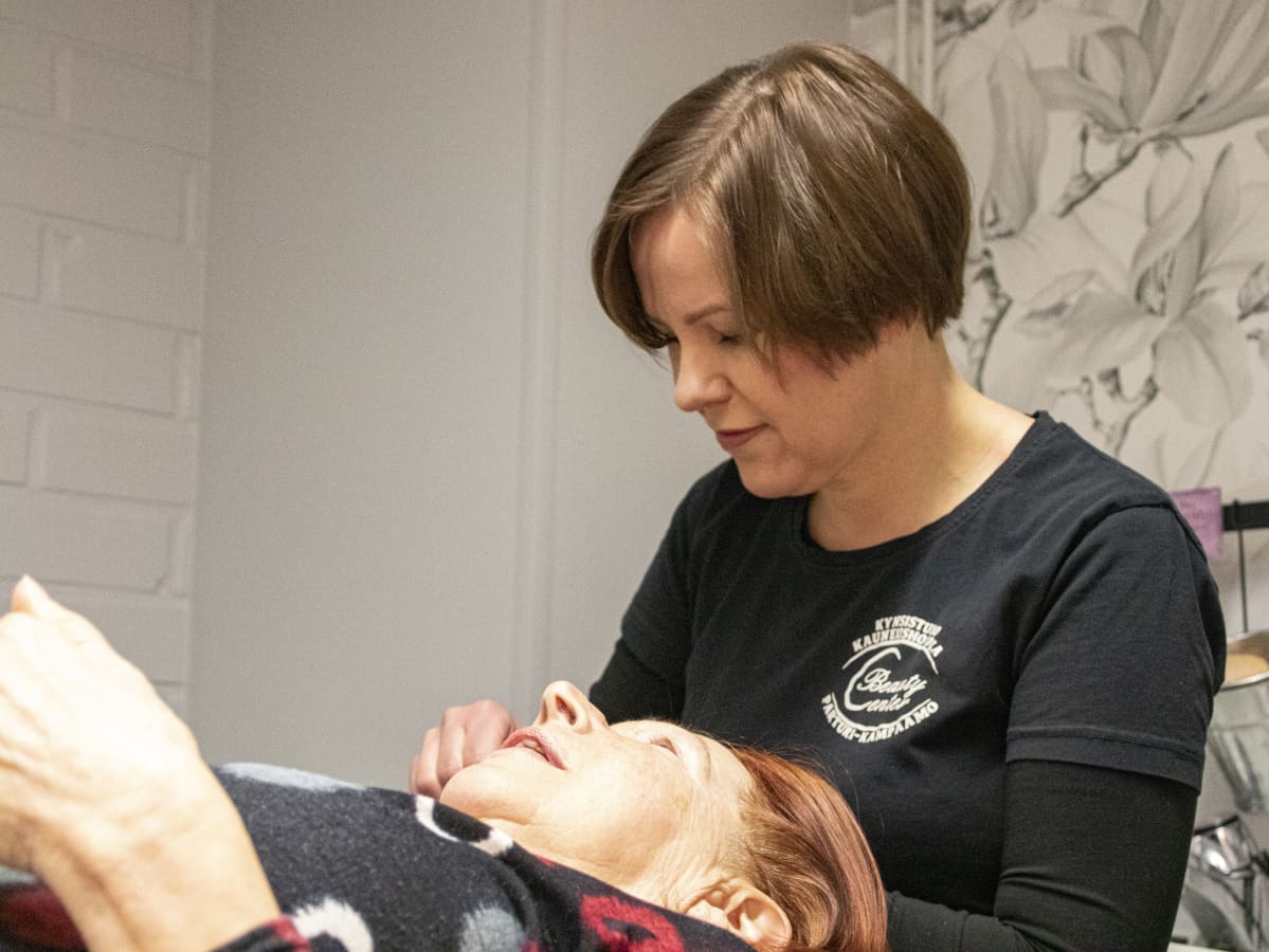 Tanja Nikku hoitamassa asiakkaansa kulmakarvoja.