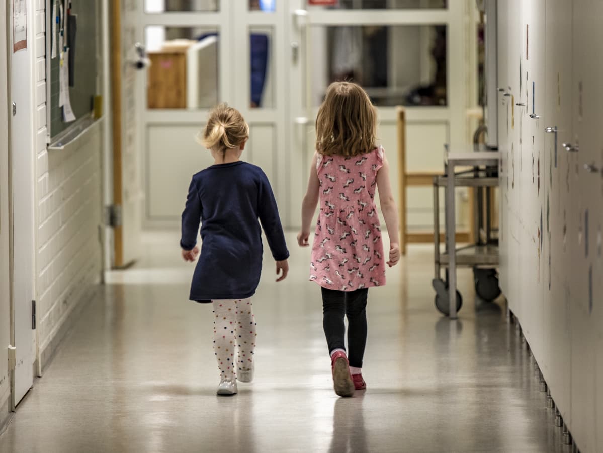 Kaksi tyttölasta kävelee käytävällä