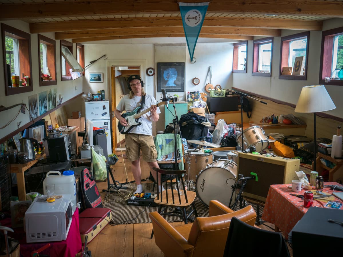 Mies soittaa studiossa.