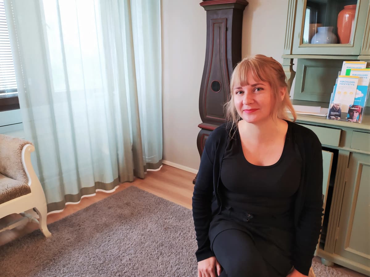 Kvinna sitter på en stol i ett rum.