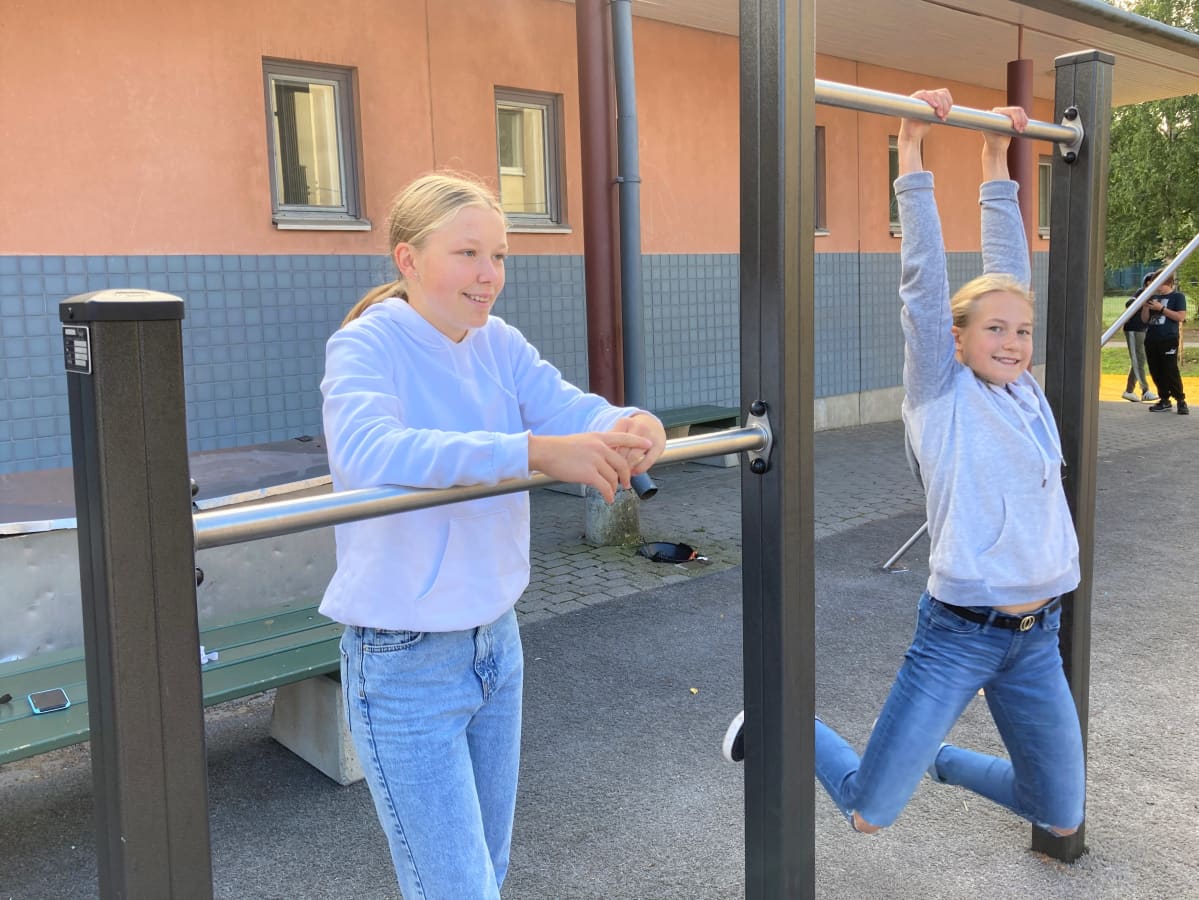 Kuvassa Aava Tammilehto ja Aino Kaariskorpi Merilahden peruskoulun pihalla.