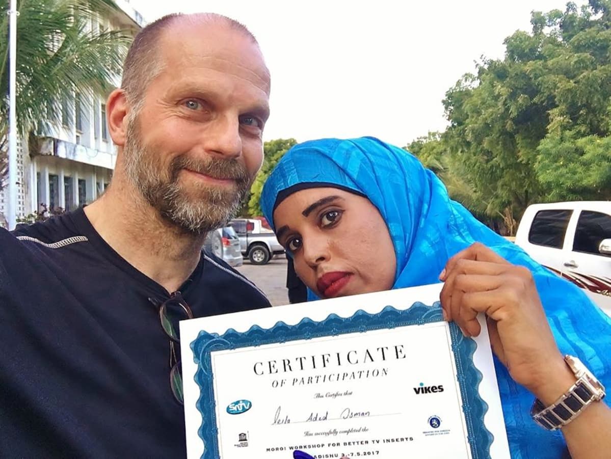 Kouluttaja Pasi Toivonen ja uutistuottaja Leila Aded Osman uutisinserttikoulutuksen todistuksen kanssa.