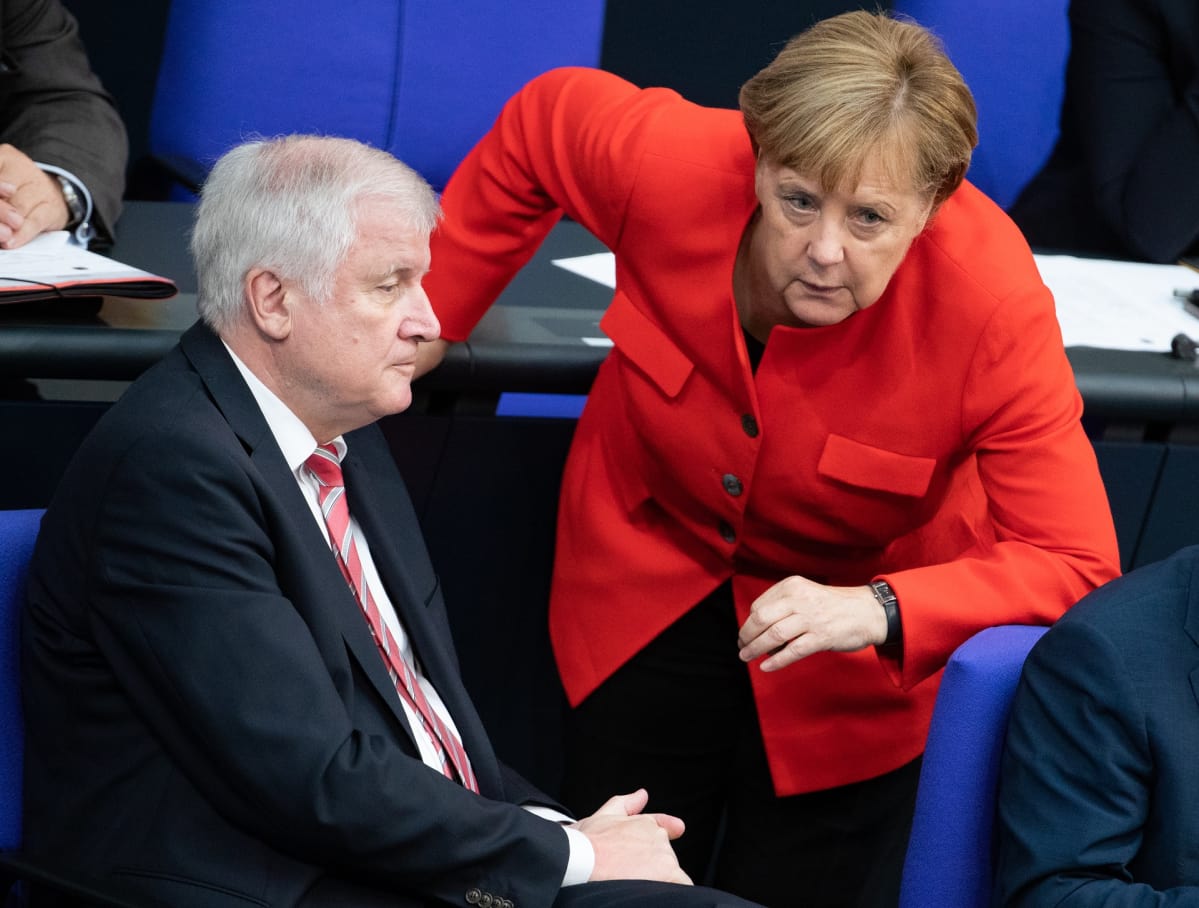 Seehofer ja Merkel keskustelevat liittopäivillä.
