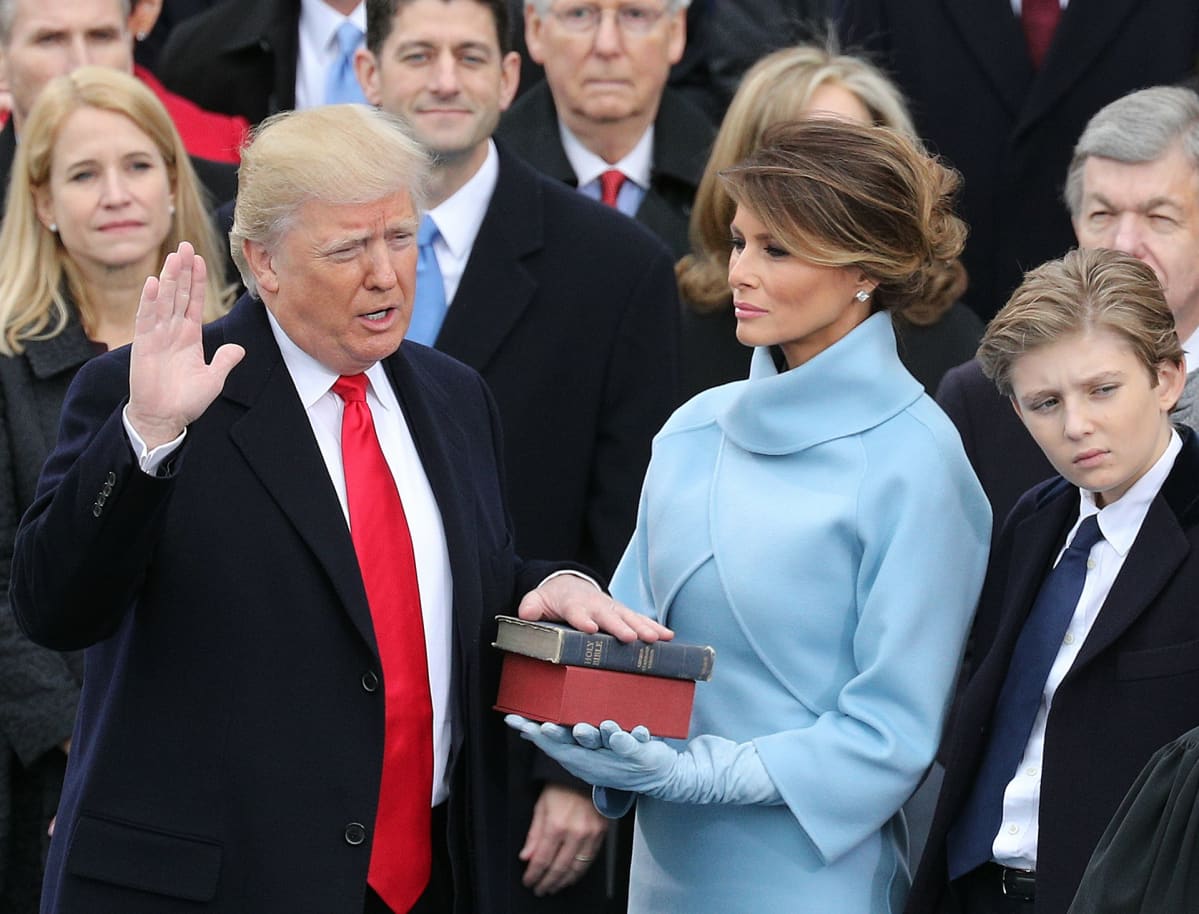 Donald Trump vannoo virkavalaansa. Vieressä vaimo Melania.