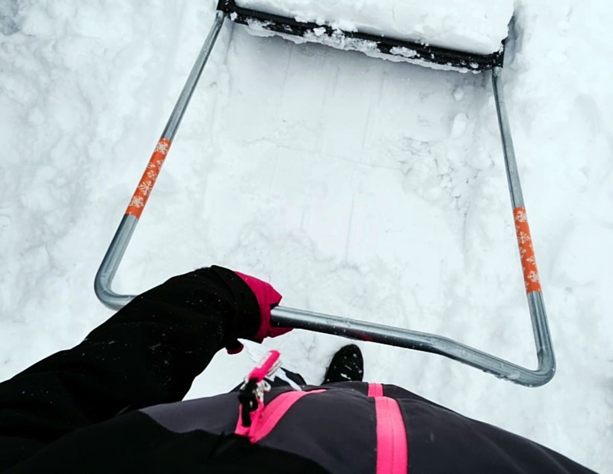 Ihminen kolaa lumia.