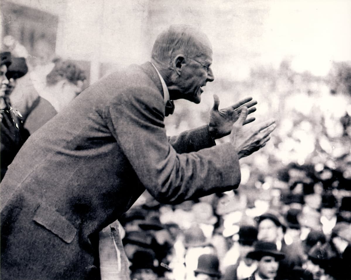 Eugene V. Debs puhuu yleisölle korokkeelta elehtien kiihkeästi.
