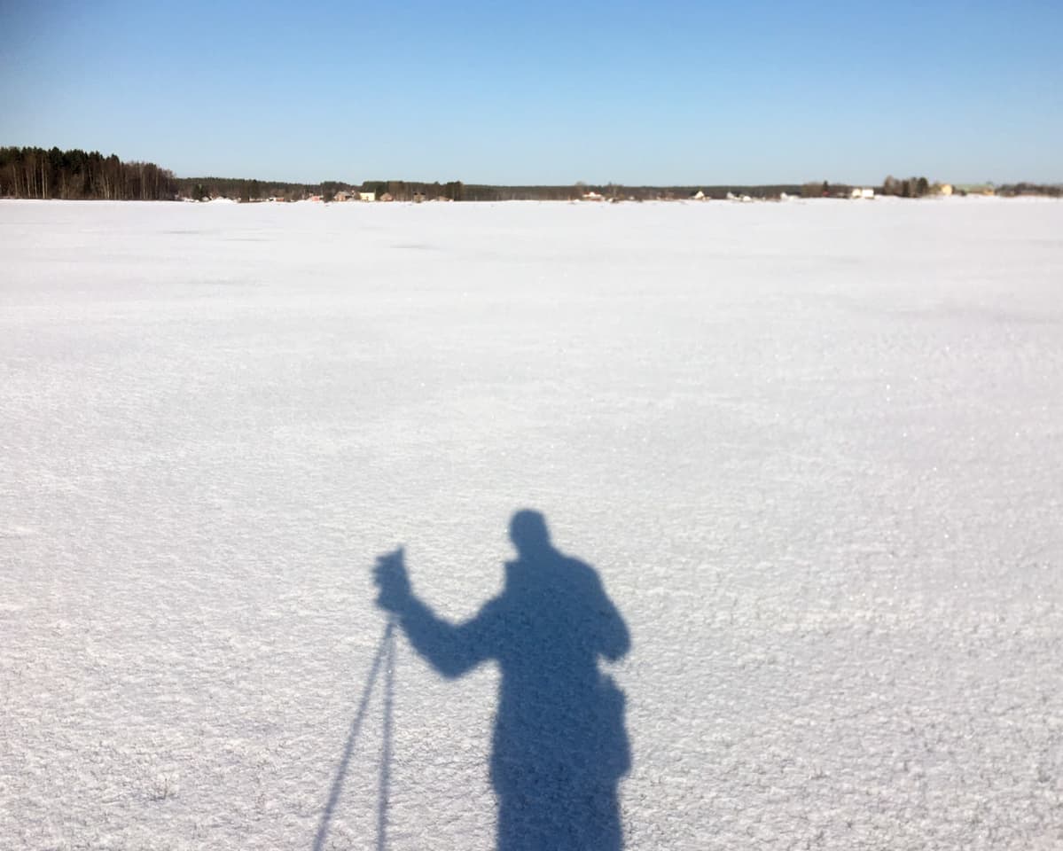 Valokuvaaja Jaakko Heikkilän varjokuva Tornionjoen jäällä maaliskuussa 2020.