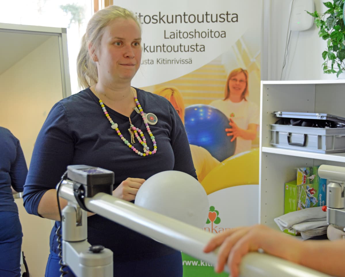 Fysioterapeutti Riina Puutio pallottelee Eemi Laurilan kanssa kävelymatolla.