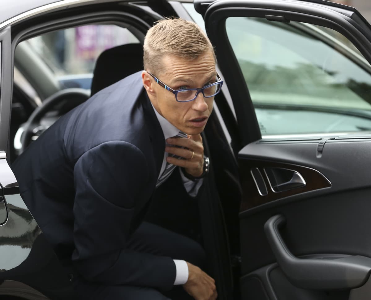 Alexander Stubb korjaa kravattiaan noustessaan auton takapenkiltä.