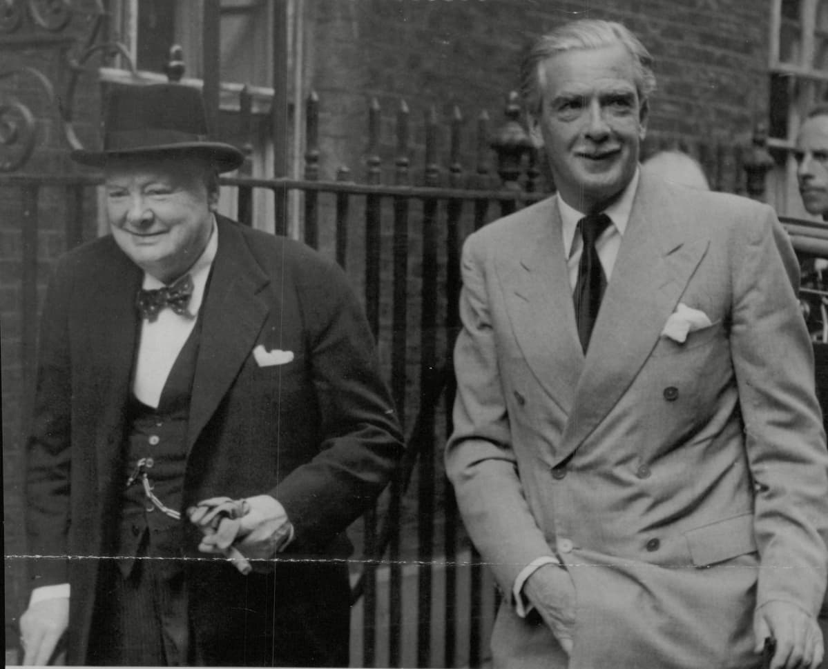 Winston Churchill ja Anthony Eden kävelevät rinnakkain kadulla.