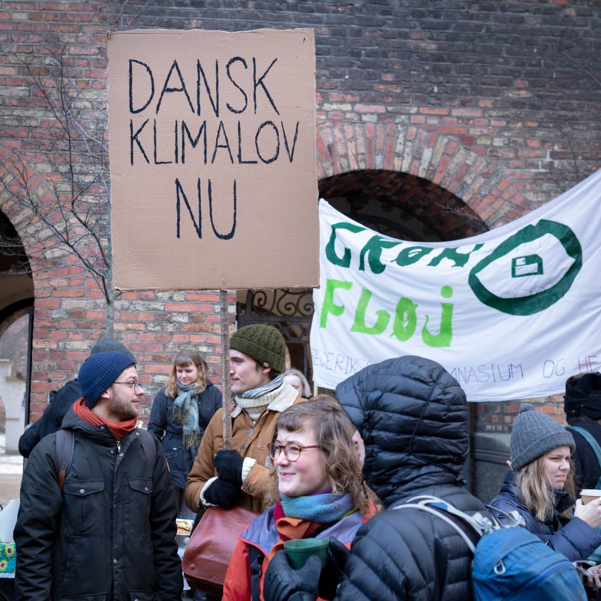 Mielenosoittaja kädessään kyltti, jossa lukee "tanskalainen ilmastolaki nyt"