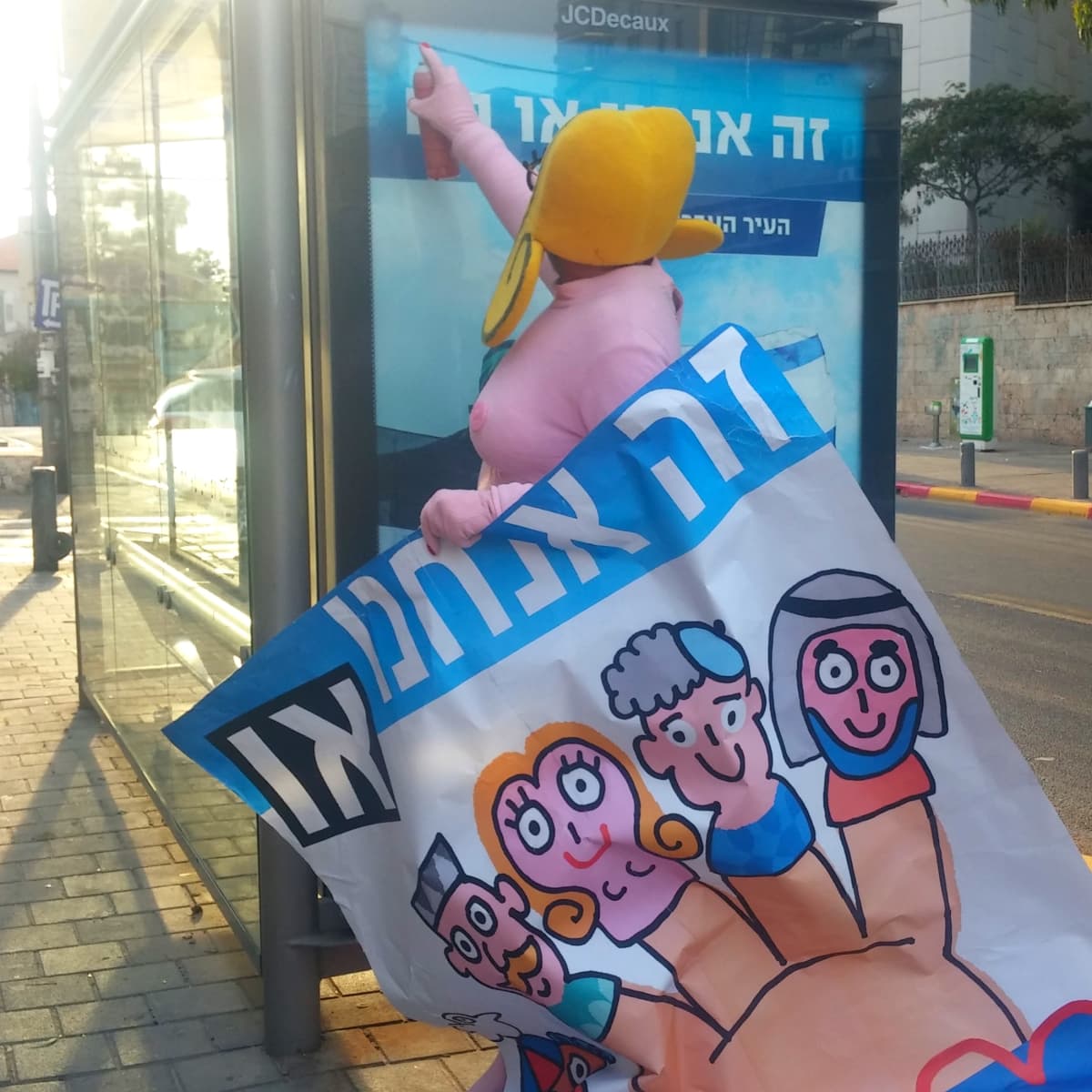 Shosken uusi aluevaltaus on peittää rasistisia ja erimielisyyttä ruokkivia julisteita omilla julisteillaan, jotka julistavat rakkautta ja veljeyttä.