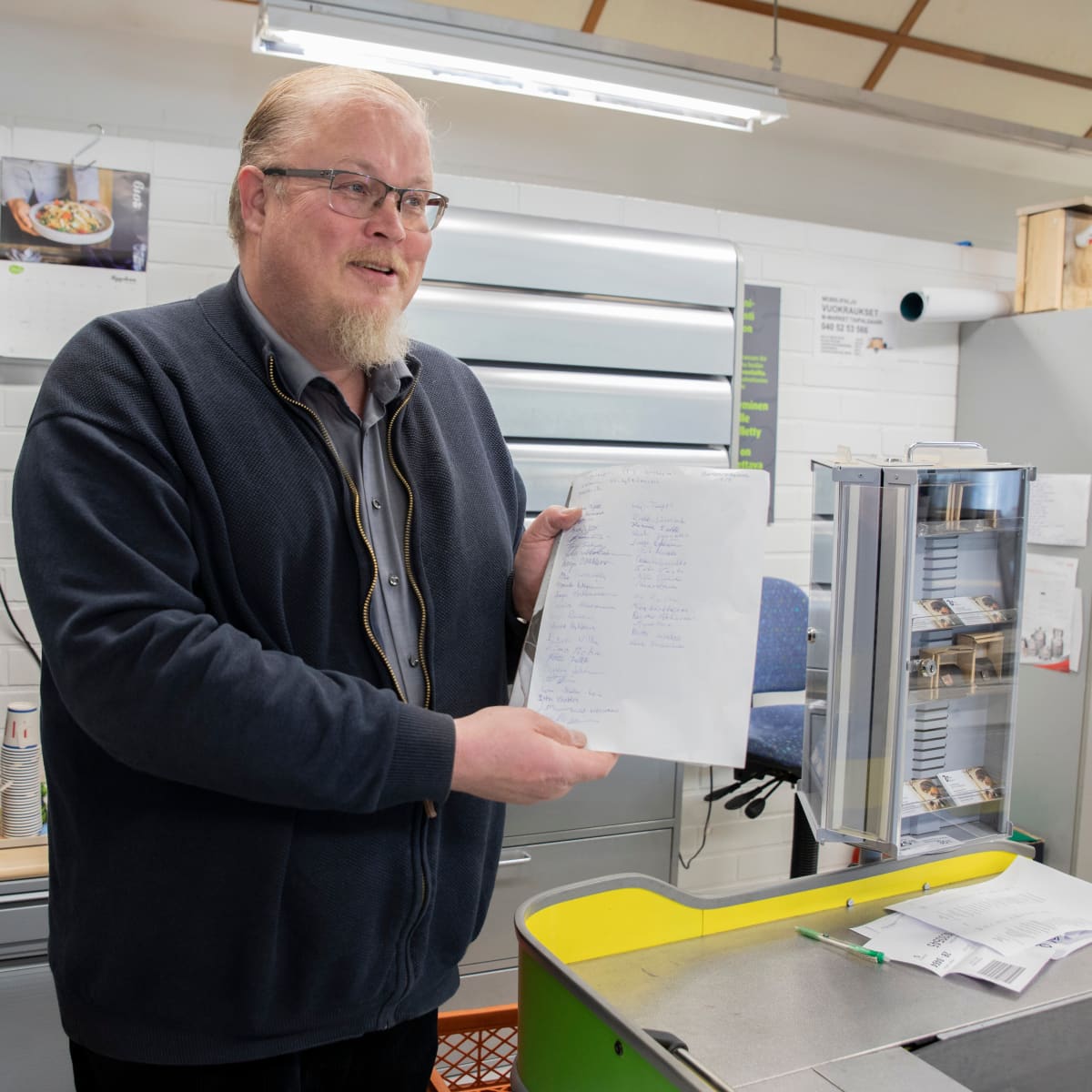 Taipalsaaren M-kauppias Osmo Laine ja hänen keräämänsä adressi.