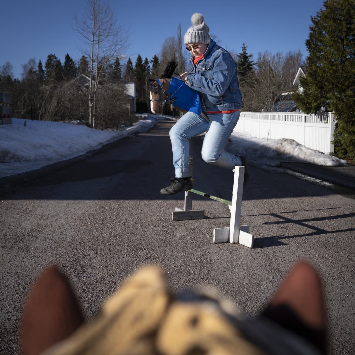 Jenny Kärkkäinen ratsastaa keppihevosella.