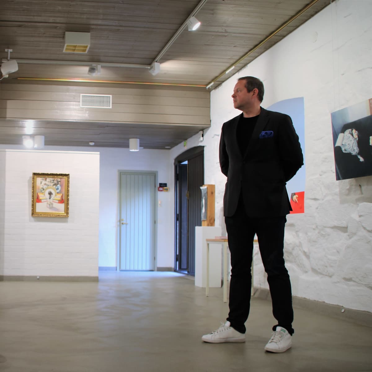 Tommi Laitinen seisoo galleriassa.