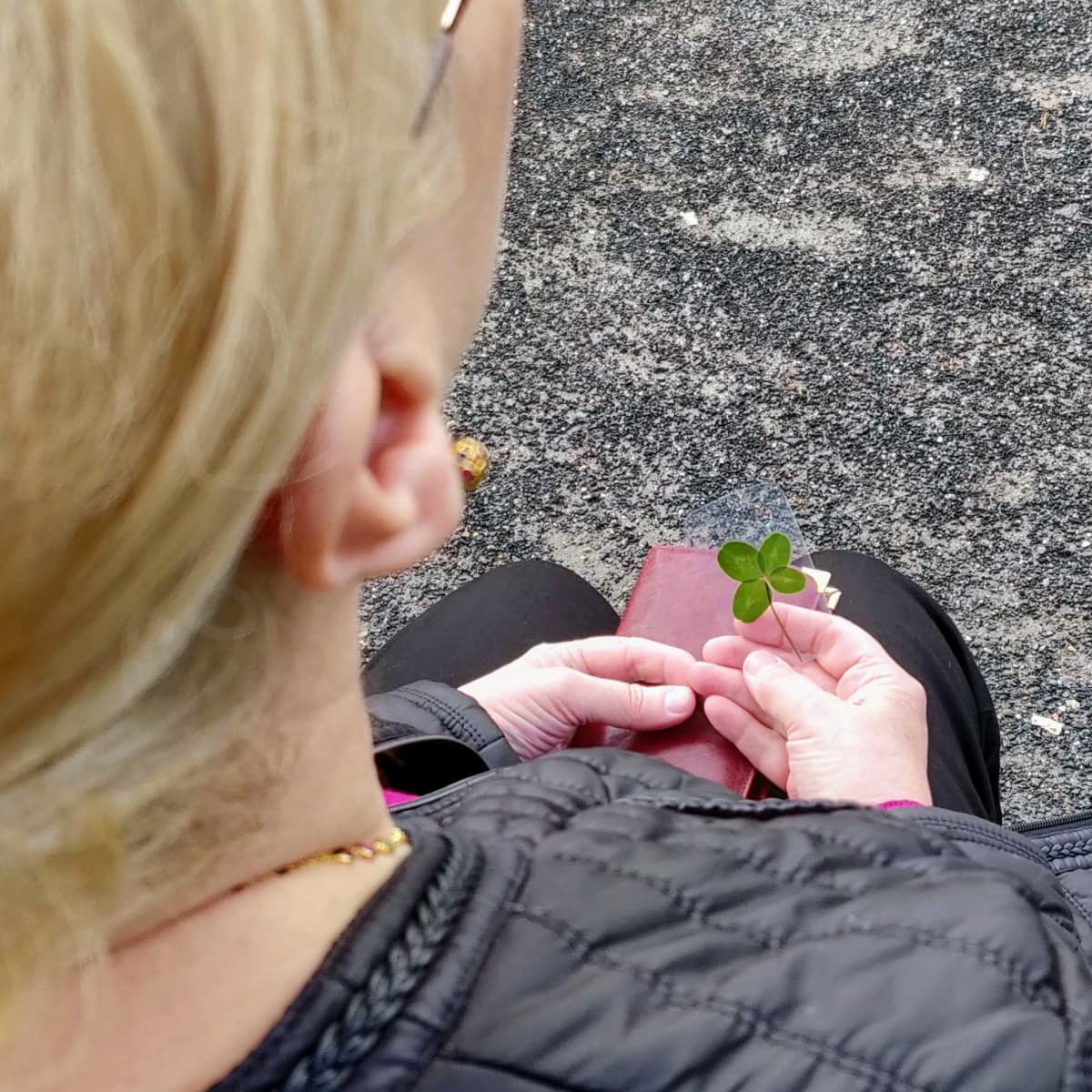 Aino Peltosen sylissä on lompakko ja neliapilasta tehty voimakortti.