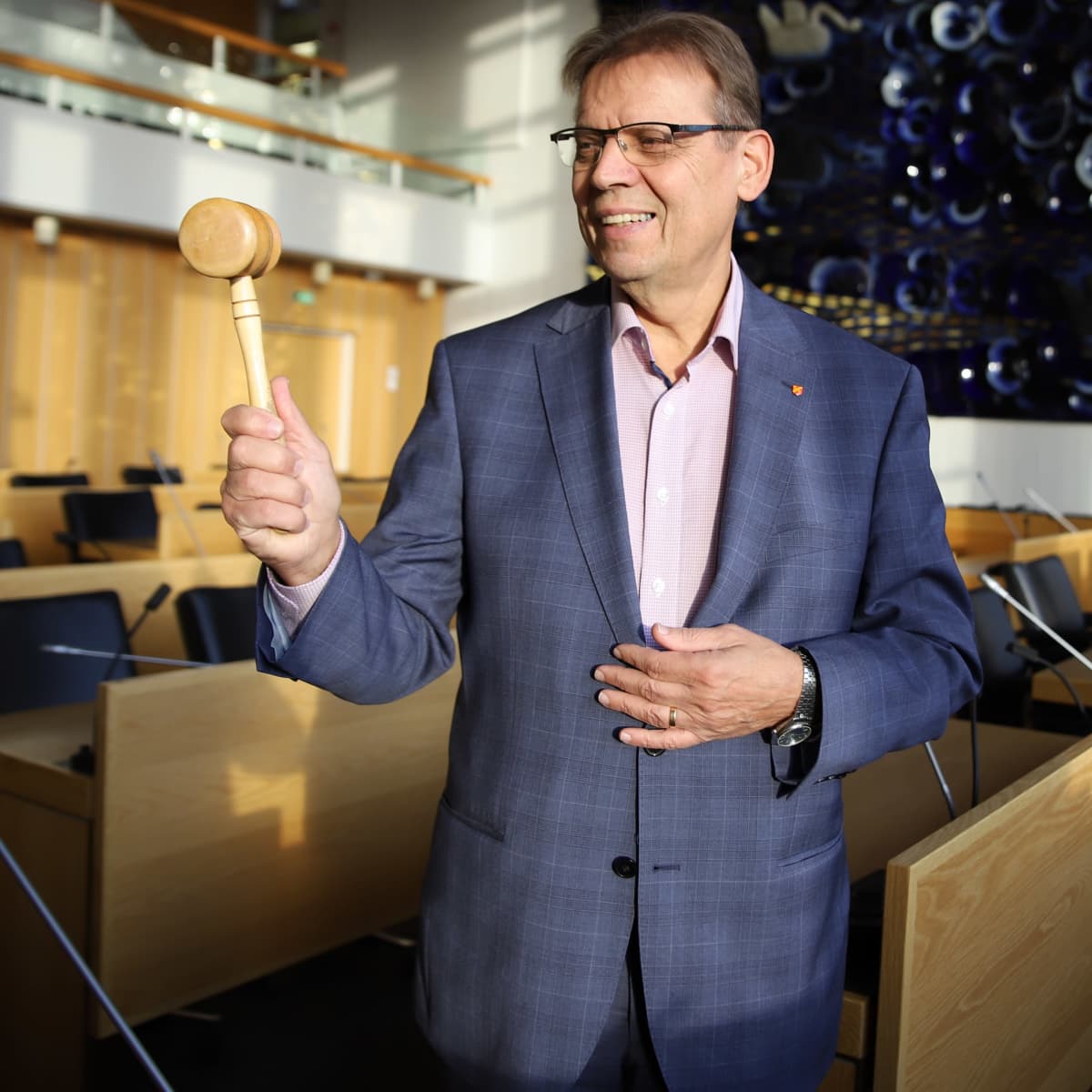 Lauri Lyly pitää kädessään puheenjohtajan nuijaa.